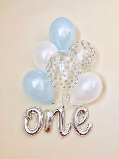 One script foil balloon Measures 27" x 14" Includes a straw for easy inflation and a ribbon for hanging. 2 light blue latex balloons 2 silver confetti balloons 2 white latex balloons This gorgeous blue and silver balloon combination will look stunning hanging against a wall. Simply inflate it with air and add it to your party decorations. The balloons are supplied uninflated. Foil balloons suitable for air inflation only. E Cursive, Mr Onederful Birthday, First Birthday Decor, Winter Onederland Birthday Party, First Birthday Balloons, Onederland Birthday Party, Silver Confetti, Baby Boy 1st Birthday Party, Winter Onederland Birthday