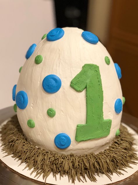 Dinosaur egg cake 1st birthday buttercream egg shaped cake. This egg shape was my first ever hand carved cake! 😁 Egg Dinosaur Cake, Dinosaur Cake For 1st Birthday, Dinosaur 1st Birthday Cake Smash, Dinosaur Themed Smash Cake, Dino Cake First Birthday, Dinosaur Birthday Smash Cake, Dinosaur Egg Smash Cake, 1 Year Dinosaur Birthday, Dino 1st Birthday Cake