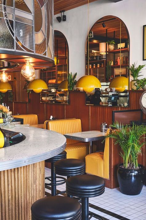 Yellow retro-inspired interior of Egghead Diner in Cape Town, South Africa Small Diner Design, Essen, 70s Restaurant Interior Design, Diner Design Ideas, American Restaurant Aesthetic, 70s Bar Decor, 70s Style Bar, Diner Counter Design, Diner Interior Design Retro