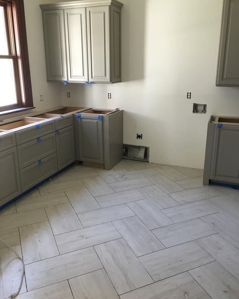 Love this herringbone tile pattern in this amazing laundry room that's in the works! Light Gray Herringbone Tile Floor, Tile Floor For Laundry Room, Luxury Vinyl Tile Living Room, Herringbone Floor In Kitchen, Kitchen Tile Floor Herringbone, Engineered Tile Flooring, Kitchen Herringbone Tile Floor, Large Herringbone Tile Floor Kitchen, Large Tile Herringbone Floor