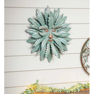 Bring unique style and personality to your space with our Green Man distressed wall decor. Adds wonderful color and dimension to any interior or exterior wall, even your front door. Crafted of iron and featuring a light green verdigris look, this piece instantly elevates any space you hang it. It honors a centuries-old architectural tradition of depicting a man with leaves integrated into its features. The detailed laser-cut metal leaves fan out in a layered, circular pattern with the wise man's Wood Panel Wall Decor, Outdoor Metal Wall Art, Distressed Walls, Laser Cut Metal, Accent Wall Decor, Circular Pattern, Wood Panel Walls, Metal Leaves, Wall Decor Set
