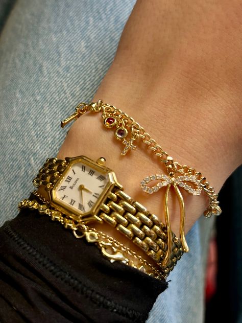 Charm bracelet Bow charm Gold watch Gold charms Gold Watch Jewelry, Jewerly Stacks Gold, Bracelet Stack With Watch Gold, Bracelets Gold Aesthetic, Maximalist Gold Bracelets, Women In Jewelry, Jewelry Charm Bracelets, Stacked Bracelets With Watch Gold, Charm Bracelets Ideas