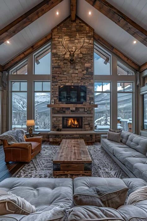 This living room captures the essence of a mountain lodge, featuring wooden beams and a stone fireplace. Fur rugs and antler decor add layers of warmth and rustic elegance. Embrace these rustic living room ideas for a home that's as inviting as a mountain retreat. Explore similar styles like ski chalet chic, alpine luxury, and rustic contemporary for your living space. Discover the full series of 16 mountain lodge inspired living rooms. Cabin Like Living Room, Cabin Fireplace Stone, Cabin Like Homes Interior, Mountain House Interior Design Rustic, Ski House Living Room Decor, Beams In The Living Room, Alpine Lodge Interior, Ski Living Room, Antler Living Room Decor