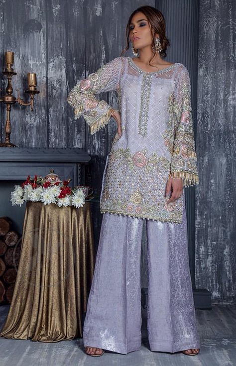 Standout in this gorgeous chiffon shirt embellished with tilla, kora dabka, sequins and pearls. It is further enhanced with floral thread embroidery. Its hemline and sleeves are beautifully decorated with golden tassels. It is beautifully coordinated with self embroidered jacquard bell bottom trousers. Pastel Pakistani Outfit, Pakistani Wedding Guest Outfits, Pakistan Outfits, Pary Dress, Asian Fits, Asian Attire, Trouser Designs, Desi Dresses, Pakistani Fashion Casual