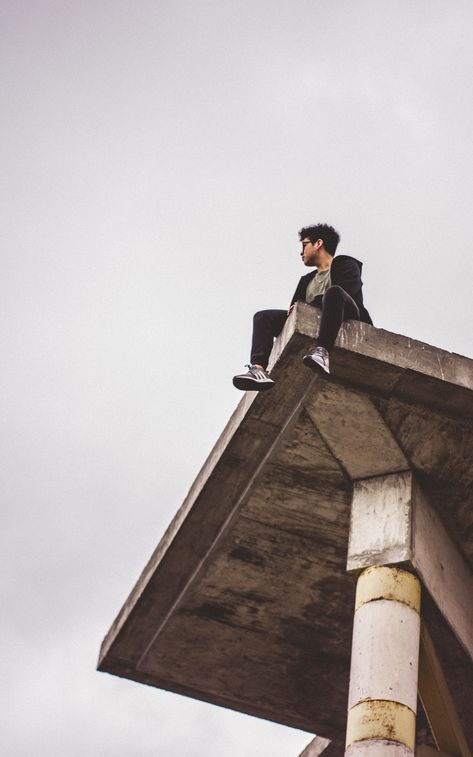 low angle photography of man sitting on ledge during daytime, NIKON CORPORATION, NIKON D5200, #241F1D Man Sitting On Ledge Reference, Croquis, Sitting Over Ledge Pose, Sitting Poses Low Angle, Sitting On A Ledge Reference, Low Angle Pose Reference Sitting, Sitting On Roof Reference, Sitting High Angle Pose Reference, Sitting On A Ledge Pose