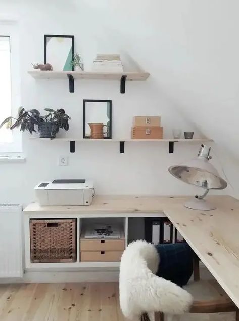 Picture of a small attic Nordic home office with floating desk with storage, wall mounted shelves, cool lamps and a comfy chair Home Office Attic Slanted Ceiling, Slanted Ceiling Office, Small Attic Office, Attic Office Ideas, Floating Office Desk, Nordic Home Office, Office Bedroom Combo, Living Room Office Combo, Attic Room Ideas