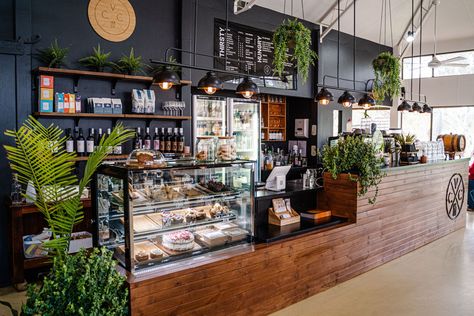 Our beautiful front bar of the cafe. With rustic wood, greenery and dark tones. Bakery Interior Design Vintage, Deli Decor Ideas, Bakery With Plants, Moody Cafe Interior, Cafe Set Up, Dark Cafe Interior, Coffee Shop Food Ideas, Cafe Counter Ideas, Cafe With Plants