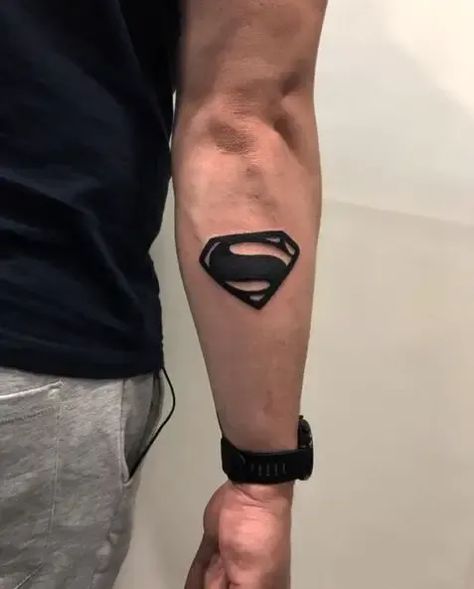 Superman tattoos that will unleash your inner hero! From cool symbols to powerful portraits, find the perfect design to show your love for the Man of Steel. #SupermanTattoo #HeroInYou Super Man Tattoo Design, Ubermensch Tattoo, Superman Symbol Tattoo, Arm Small Tattoo Men, Superhero Tattoo Ideas, Super Man Tattoo, Superhero Tattoos For Men, Black And Red Tattoo Men, Superman Tattoo For Men