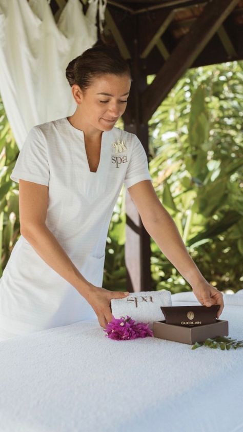 A spa therapist wearing a custom embroidered white spa tunic and spa trousers. Spa Therapist Uniform, Resort Uniform Ideas, Massage Therapist Uniform Ideas, Spa Uniform Ideas, Resort Uniform, Spa Tunic, Spa Uniforms, Hotel Uniforms, Spa Wear