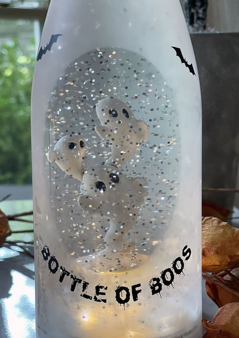 Light up your Halloween night with the Bottle of Boos! This frosted glass wine bottle is filled with swirling silver glitter and three spooky ghosts. Dare to be daring and stand out from the crowd with Bottle of Boos! It's the perfect way to add some extra sparkle to your night. 11.75 Inch Tall x 3.25 Inch Diameter 3 x AAA Batteries Sold Separately Continuous swirling silver glitter Lighted snow globes are the hit of the Halloween season. Looking for the perfect hostess gift, this one, they will Wine Bottle Repurpose, Halloween Sensory Bottles, Ghost Bottle, Halloween Wine Bottle Crafts, Sleepover Crafts, Wine Bottle Lanterns, Alcohol Bottle Crafts, Spooky Crafts, Glitter Wine Bottles