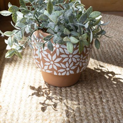 Create a traditional boho aesthetic with this whimsical terracotta pot exclusively from Foreside Home and Garden. Hand thrown by artisans in India, this planter is characterized by a dainty white flower pattern that is hand painted and stands out against the natural terracotta clay background. Add a touch of warmth to your indoor and outdoor spaces. | Foreside Home & Garden Terracotta Pot Planter 6.0 x 6.0 x 6.0 in | AORE5752 | Wayfair Canada Terracotta Pots Front Yard, Paint Planters Pots, Fun Flower Pots, Planter Designs Painted, Painted Potted Plants, Terracotta Pot Paint, Decorated Terra Cotta Pots, Spray Paint Flower Pots, Painting Pots Ideas Aesthetic