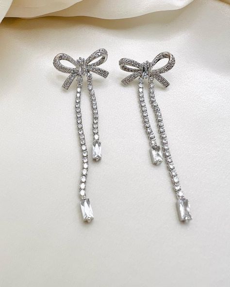 Description: bow knot earring encrusted with 3A cubic zirconia, Rhodium plated brass. Measurement: 6.8 length, bow 2.2cm x 1.2cm Silver Glitter Jewelry, Silver Earrings Elegant, Silver Dangling Earrings, Silver Prom Earrings, Dangly Silver Earrings, Cute Silver Earrings, Elegant Silver Jewelry, Silver Elegant Earrings, Diamond Earings