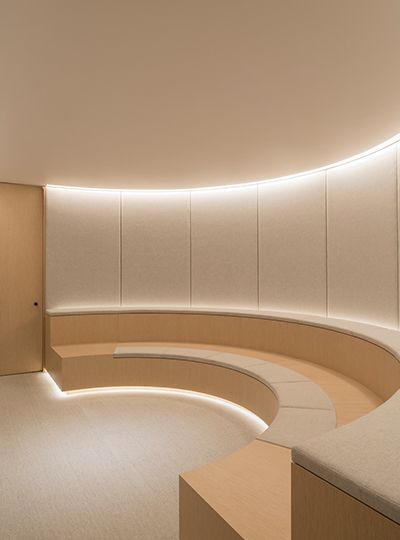 Nulty - Executive Offices, London - Workplace Amphitheatre Sleek Stylish Design Tiered Oak Seating Fabric Acoustic Panels Subtle Integrated Halo Lighting Scheme Office Amphitheatre Design, Amphitheatre Architecture, Tiered Seating Office, Small Auditorium Design, Acoustic Interior, Amphitheater Architecture, Halo Lighting, Lighting Scheme, Integrated Lighting