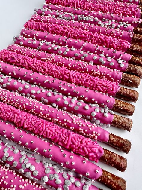 This listing is for 12 chocolate covered pretzels. Each fresh pretzel rod is dipped in creamy hot pink chocolate and decorated with 4 different sprinkles. A perfect addition to a dessert table, a birthday party or shower. So beautiful that all the guests will want one.  Each favor will arrive to you individually wrapped in a clear cellophane sleeve and tied with color coordinating ribbons.  Delightful Chocolates cannot be held responsible for melted chocolate once the package has left our facility. We take great pride in insulating our boxes and packaging with ice sheets if needed PLEASE PURCHASE ICE SHEETS IF YOU LIVE IN A WARM CLIMATE. WE WILL NOT SHIP IF YOU ARE IN TEMPERATURES OF 65 DEGREES OR ABOVE  These confections were crafted in a workplace that also processes peanuts and other tr Pink Cake Push Pops, 18th Bday Party Ideas Pink, Pink Brunch Birthday, Y2k Party Desserts, Aesthetic Pink Dessert, Pink Food For Birthday Party, Hot Pink Chocolate Covered Pretzels, Hot Pink And Black Dessert Table, Hot Pink 21st Birthday Decorations