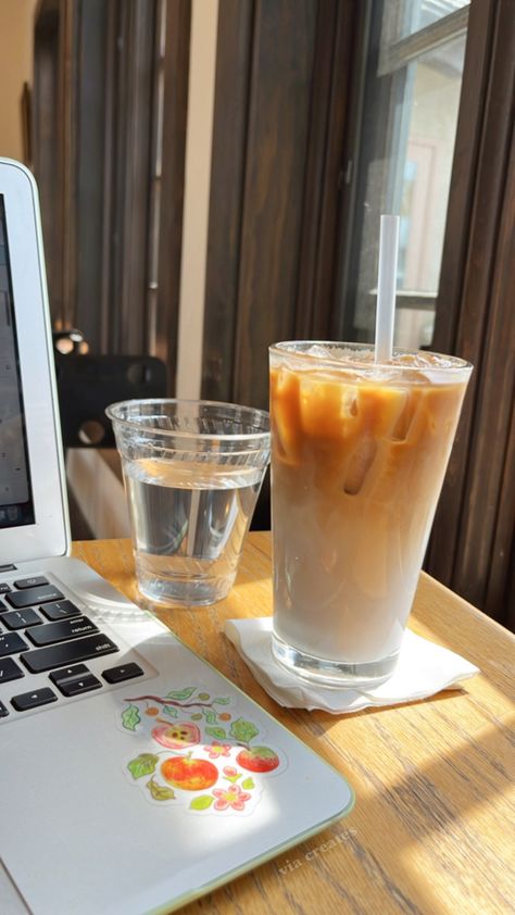 An iced latte, a cup of water, and a laptop sit on a cafe table next to a sunny window Blueberry Makeup, Blueberry Latte, Afternoon Vibes, Sunnies Cafe, Aesthetic Studying, Coffee Study, Cafe Aesthetic, Sunny Window, Cafe Table