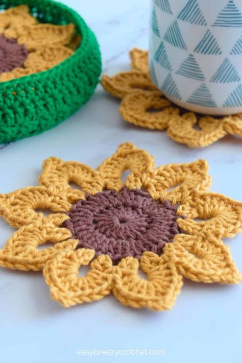 Easy Crochet Sunflower Coasters With Basket | Easy Breezy Crochet Crochet Coaster Beginner, Crochet Floral Coaster, Crochet Pattern Flowers Free, Crochet Coaster Holder Free Pattern, Pumpkin Coasters Crochet, Free Crochet Coaster Patterns Easy, Small Cotton Crochet Projects, Flower Pot Coasters Crochet Pattern Free, Crochet Kitchen Decor