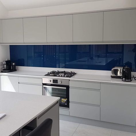 Stunning Inky Blue glass Splashback- a perfect contrast to this kitchens light grey cabinets, and white work surfaces. Did you know we… Blue And Grey Kitchen Cabinets, Blue Splashback Kitchen, Blue And Grey Kitchen, Kitchen Bulkhead, Nice Kitchens, Lakehouse Kitchen, Kitchen Soffit, Glass Splashbacks Kitchen, Kitchen Splash Back