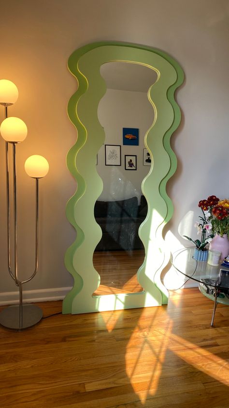 green curvy mirror (floor length) next to white globe light and glass table with vase of flowers on top. Retro Mirror Diy, Full Mirror Aesthetic, Fun Mirrors Bedroom, Wavy Interior Design, Diy Curvy Mirror, Vinyl Mirror Decals, Unique Interior Design Creative, Mirror Ideas Aesthetic, Cool Mirror Ideas