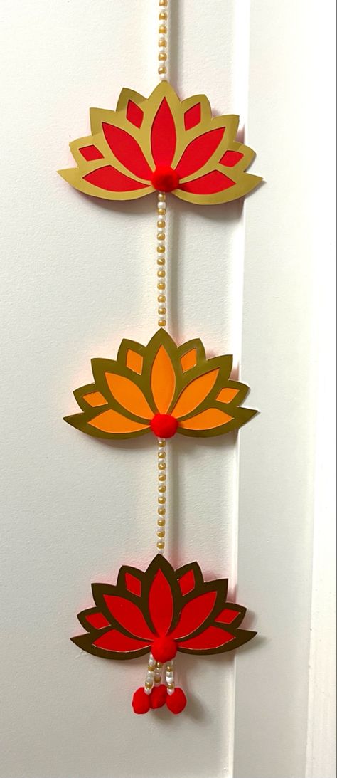 Paper crafted wall hanging with traditional lotus cutouts. Diy Lotus Wall Hanging, Lotus Hanging Decoration, Arangetram Decor, Lotus Cutout, Holi Ideas, Lotus Wall Hanging, Diwali Card Making, Traditional Wall Hanging, Lotus Decor