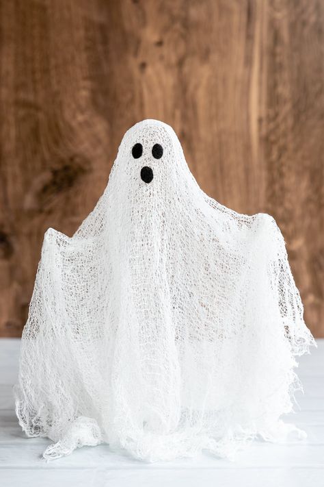 Make your own cheesecloth ghosts with this easy tutorial using glue or Mod Podge. Kids will love making their own spooky glow-in-the-dark ghosts for Halloween. Ghosts Made From Cheese Cloth, How To Make Cheese Cloth Ghost, Sheet Ghost Decoration, Ghost Fireplace Decor, Halloween Mod Podge Crafts, How To Make Gauze Ghosts, Midge Podge Ghost, Muslin Cloth Ghosts, Diy Ghost Candle Holder