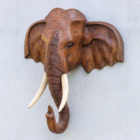 If you're looking for a show-stopping piece of decor this wall sculpture from Thailand's Amporn is just the ticket. Hand carved from rich teak wood the sculpture features fine details that bring the elephant to life. Two ivory darabela wood tusks complete the illusion. Thailand Wood Carving, Elephant Wood Art, Wooden Animal Carvings, Wood Elephant Carving, Wooden Elephant Carving, Ceramic Elephant Sculpture, Elephant Wood Carving, Modern Wall Decor Bedroom, Wooden Sculpture Art