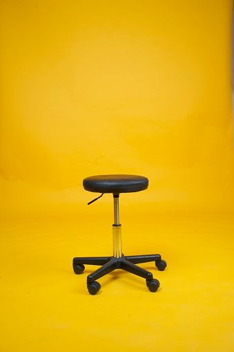 Black stool chair with wheels over an isolated yellow background. Chair Editing Background, Studio Png Background, Background For Photoshop Editing, Chair Background For Editing, Yellow Colour Background, Photo Studio Design Backgrounds, Job Background, Rdx Editor, Watches Video