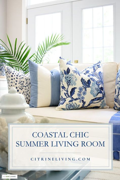 Preppy coastal chic is a classic, crisp way to dress up your living room! Create a stunning look with gorgeous prints layered with throw pillows, blankets and accented with all things coastal: lush palms and coral sculptures mixed in with a blue and white palette is always coastal chic! See more tips + learn how to create a stunning coastal haven here: https://citrineliving.com/coastal-chic-summer-living-room-decor/ Blue Southern Living Room, Nantucket Living Room Style, Costal Living Room Tv Wall, Coastal Farmhouse Pillows, Blue And White Living Room Decor Ideas, Nantucket Coastal Style, Modern Farmhouse Blue Living Room, Blue And White Living Room Throw Pillows, Preppy Coastal Living Room