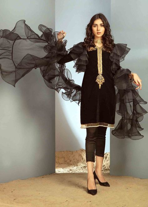 Include: Shirt Pants Dupatta Addons: Mask [+PKR 1670] Fabric: Shirt: Velvet Pants: Cotton Silk Dupatta : Organza Color: Black Work Technique: Embellished Description: This Beautiful, elegant Jet Black Straight velvet Silhouette is embellished with beautiful handwork of stones kora and nakshi on neckline styled with organza frills on arm holes to give it a chic look paired up with straight capri pants. To make this statement piece more chic it is styled with organza Frill dupatta This is a 3 Piec Velvet Short Kurti, Short Kurti Pant, Frill Dupatta Designs, Ruffle Dupatta, Black Velvet Shorts, Plazzo Suits, Velvet Short, Kurti Pant, Short Kurti