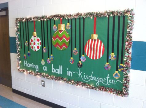 Christmas Bulletin Board - Christmas garland and lights, big ornaments made from bulletin board paper and paint and accented with ribbon, students colored ornaments. Hand painted words. Having a Ball in Kindergarten! Christmas Wreath Bulletin Board, Christmas Ornament Bulletin Board, Christmas Wall Displays Classroom, Boletin Board For Christmas, Office Christmas Bulletin Board, Christmas Fireplace Bulletin Board, Unique Christmas Bulletin Board Ideas, Christmas Gift Bulletin Board, Christmas Bulletin Board Ideas For Daycare