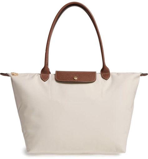 Classic in style, The Longchamp Le Pliage Tote is made from water-resistant nylon with an embossed leather trim. This bestseller is versatile enough for school, the office or traveling the world. It comes in a range of chic shades and folds flat for storage. We love it and we're sure she will too! Check out this ultimate gift guide for women who love to explore! #TravelFashionGirl #TravelFashion #travelgiftideas #giftideasforwomen #bestgiftsforwomen #uniquegiftsforher #womensgiftguide Le Pilage Tote, Longchamp Large Le Pliage Tote, Longchamp Le Pliage Large, School Purse, Longchamp Tote, Best Travel Gifts, Tote Bags For School, Handbags For School, Travel Purse