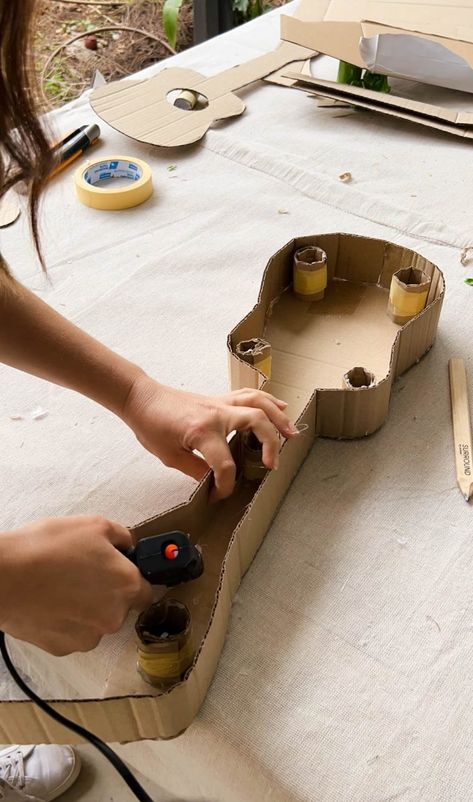 A Pair & A Spare | Making a Kids Cardboard Guitar How To Make Guitar With Cardboard, Guitar Box Diy, Diy Cardboard Guitar, How To Make A Guitar Out Of Cardboard, Cardboard Guitar Diy, Kids Guitar Craft, Guitar Cardboard, Guitar Art Diy, Dramatic Play Diy