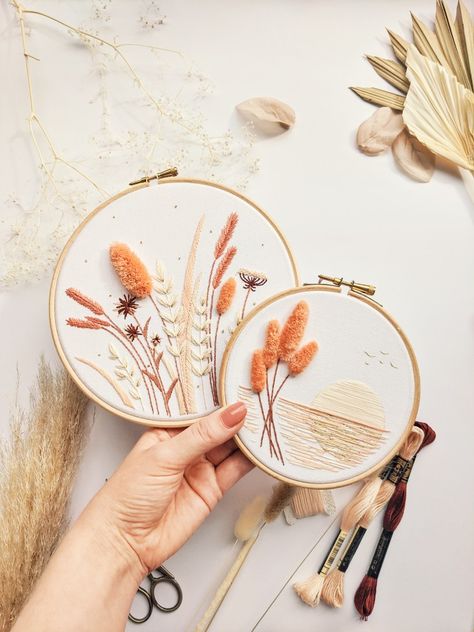 Two matching embroidery hoops are being held in a hand. One embroidery hoop has a wildflower meadow design and the other has a design of lake at sunset. Couture, Patchwork, Pampas Embroidery, Idea Embroidery, Meadow Embroidery, Aesthetic Embroidery, Textured Embroidery, Embroidery Scarf, Etsy Embroidery