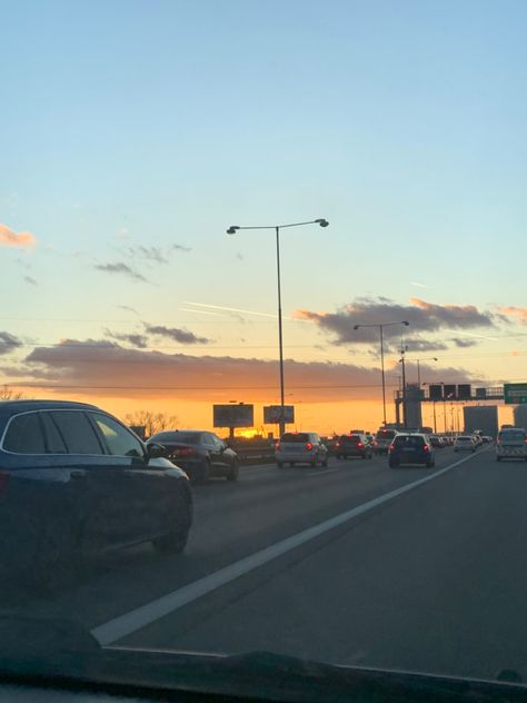 cars on a highway with a pretty orange sunset in the back with some buildings, lamps and road signs. Cars On Road, Sunset Highway, D Letter Images, Road Aesthetic, Car On Road, Sheep House, Quiet Photos, Car On The Road, Anime Face Drawing