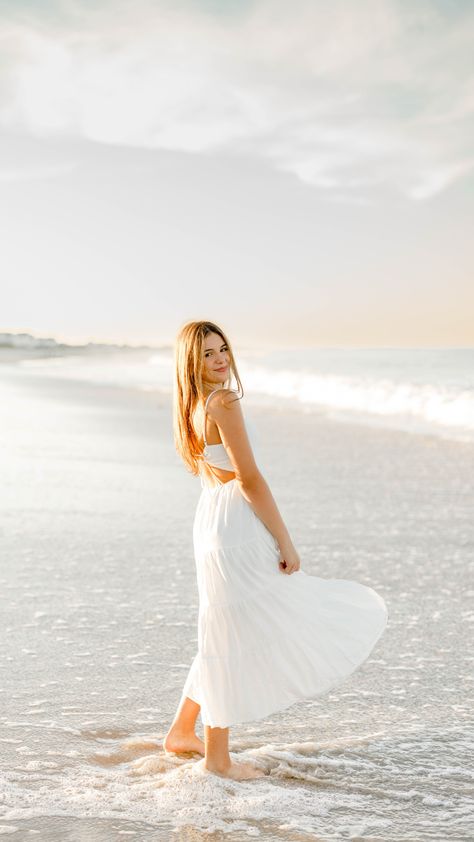 Girl wearing white dress standing in ocean at sunset Light Blue Senior Pictures, Sunrise Senior Pictures The Beach, Professional Beach Photos, Beach Photoshoot Teenagers, Beach Pictures Portrait, Senior Photo Outfits Beach, Poses By The Beach, Poses For At The Beach, Beach Photo Ideas Women