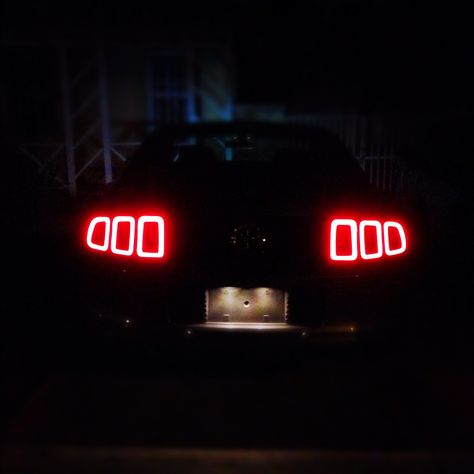 The rear tail lights of my 2013 Ford Mustang at night. Mustang Tail Lights, Mustang At Night, Mustang Night, 2013 Mustang Gt, Bugatti Centodieci, Gtr Car, Aesthetic Cool, Ford Mustang Car, Pimped Out Cars