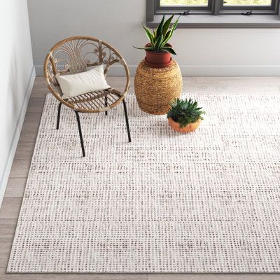This rectangular hand tufted area rug adds a textural foundation to your space. Made of a wood/cotton blend, it features a nubby weave in brown and ivory. The very low pile height of 0.02” makes it a stable wall covering for your furnishings - and also does not bunch up when you open or close the door. Envision this area rug in your beach house or in a casual space such as a den or family room. The neutral color is a match for most design schemes. We recommend the use of a pad to prevent slippag Japandi Rugs Living Room, Area Rug On Light Wood Floor, Dining Table With Rug, Neutral Bedroom Rug, Dining Table Rug Ideas, Neutral Area Rugs In Living Room, Neutral Rugs Living Room, Modern Kitchen And Living Room, Neutral Living Room Rug