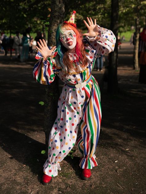 Girl in a white clown suit, half spotty, half stripey with primary colours. She has rainbow hair and a little hat and red shoes Clown Costume Makeup Cute, Bloomer, Clowncore Halloween Costumes, Vintage Clown Halloween Costume, How To Make A Clown Costume, How To Make Clown Costume, Clown Outfit Inspiration, Clown Aesthetic Costume, Clown Outfit Reference