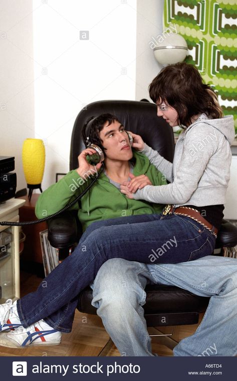 Download this stock image: teenage girl sitting on lap of boyfriend who is listening to music - A66TD4 from Alamy's library of millions of high resolution stock photos, illustrations and vectors. Croquis, Sitting Pose Reference, Couple Poses Drawing, Couple Poses Reference, People Poses, Anatomy Poses, Sitting Position, Sitting Poses, Body Reference Poses