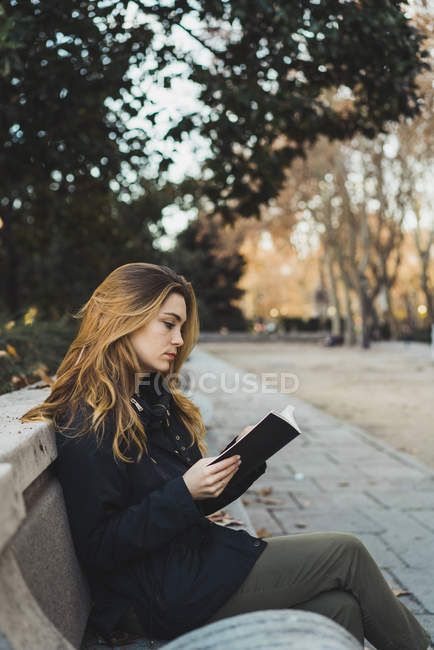 Side view of pretty woman sitting on park bench and reading book. — green, person - Stock Photo | #184794802 Sitting Reading Book Pose Reference Drawing, Book Reading Pose Reference, Holding Book Side View, Model Reading Book, Sitting Pose Side View, Side Sitting Pose, Person Reading Reference, Poses With Books Reading, Sitting On Bench Pose