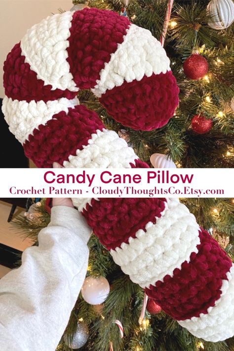 A hand holding an oversized crochet candy cane pillow in front of a Christmas tree. The  pillow is fluffy with burgundy and cream stripes. Candy Cane Pillow, Crochet Candy Cane, Crochet Candy, Crafts Cute, Crochet Kawaii, Crocheted Christmas, Crochet Xmas, Crochet Animals Free Patterns, Crochet Design Pattern