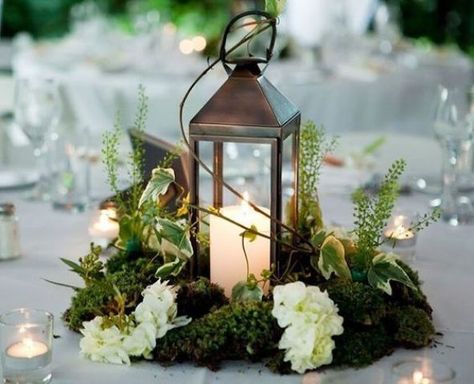 a metal candle lantern on a moss piece, with herbs and white blooms looks amazing for a woodland wedidng tablescape Non Floral Centerpieces, Moss Centerpieces, Moss Wedding, Winter Floral Arrangements, Lantern Centerpiece Wedding, Enchanted Forest Wedding, Lantern Centerpieces, Winter Floral, Wedding Lanterns