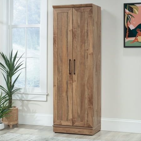 Finished in the warm and natural Sindoori Mango woodgrain, this storage cabinet with doors is versatile enough to use in any room of the home. The fashionable, framed panel doors of this farmhouse storage cabinet, accented by trendy black hardware will elevate your organization game from functional to fabulous. The enclosed back panel provides cord access to allow for hidden charging of electronic devices making this home storage cabinet perfect for a family room or game room, charging gaming consoles or controllers out of site. Four adjustable shelves of this double door storage cabinet make it perfect for use in the kitchen, providing adaptable space for tall rolls of paper towels or bulk boxes of snacks. Adjustable base levelers provide reliability in any setting, so your cabinet will b Cabinet Making, Double Door Storage Cabinet, Farmhouse Storage Cabinets, Storage Cabinet With Doors, Farmhouse Storage, Cabinet With Doors, Adjustable Base, Home Storage, Door Storage