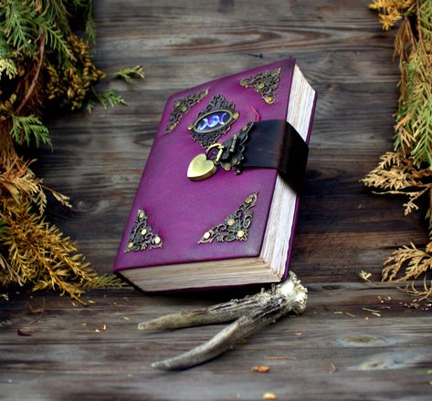 The magical pink witch grimoire is completely handmade in a cover made of genuine leather. The drawing on the skin is applied with a special gold paste based on wax, the whole style of the grimoire is vintage. It's like the Grimoire-antique witch book is hundreds of years old. The book of shadows grimoire handmade Big size book for everyday and special notes. Magic fantasy journal, This is a kind of table book of the magician, which he uses in real time and constantly adds new knowledge. * Compl Witch Grimoire, The Book Of Shadows, Fantasy Journal, Grimoire Journal, Journal With Lock, Pink Witch, Diary With Lock, Antique Journal, Softcover Notebook