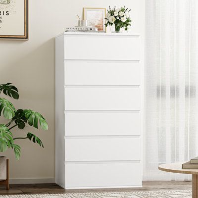 This modern white 6-drawer dresser has a simple appearance that will perfectly match your home. 6 drawers of the drawer chest can be easily pushed in and pulled out with smooth slides, and their large capacity storage space is roomy to store your items and keep your rooms neat all the time. The vertical drawer chest has a paint finish, making it easy to clean and maintain. With an anti-falling device, this chest will be stable and safe to use without any worries. Color: White | Ebern Designs Kri Tall White Dresser Bedroom, Used Dressers For Sale, Tall Narrow Dresser, Vertical Drawer, Tall White Dresser, White Dresser Bedroom, White 6 Drawer Dresser, Narrow Dresser, Tall Drawers