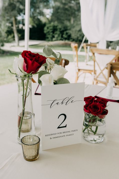 Garden Outdoor Tent Wedding Reception Decor, White and Red Roses Single Stem Flower Centerpieces, White Cardstock Table Number Signage Single Roses Wedding Table, Red White Centerpieces Wedding, Minimalist Red Wedding Decor, One Rose Centerpiece, Roses For Wedding Decorations, Red And White Roses Centerpieces Wedding, Romantic Dinner Centerpiece, Red Table Numbers Wedding, Wedding Decor With Red Roses