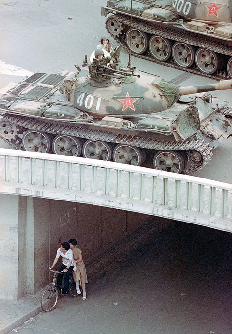 A Chinese couple on a bicycle take cover beneath an underpass as tanks deploy overhead in eastern Beijing, on June 5, 1989. (AP Photo/Liu Heung Shing) Beijing, Tiananmen Square, People's Liberation Army, Rare Historical Photos, Historical Photos, Military Vehicles, Old Photos, Location History, All About Time