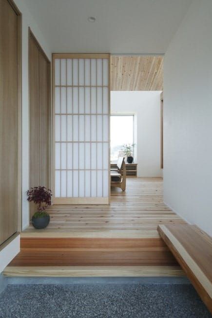 This foyer boasts a classy style with hardwood flooring and white walls, along with a Japanese-style sliding door. Modern Japanese Interior, Tatami Room, Shoji Screen Doors, Dojo Ideas, Decor Spa, Minimalist Dekor, Japanese Home Design, Japanese Style House, Japanese Interiors