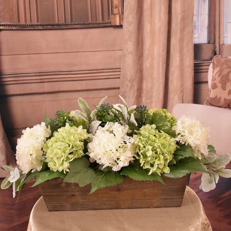 This is a perfect design for a dining table, buffet, kitchen island or coffee table. Designed from realistic-looking white and green silk hydrangeas with dainty petals accented with lambs ear and succulents.Set in a wooden planter for a casual farmhouse style. Modern Greenery Arrangements, Silk Hydrangea Arrangements, Communion Table Centerpieces, Urn Flower Arrangements Funeral, Buffet Kitchen Island, Dining Table Centerpiece Everyday, Kitchen Island Decor Centerpieces, Hydrangea Floral Arrangements, Hydrangea Planters