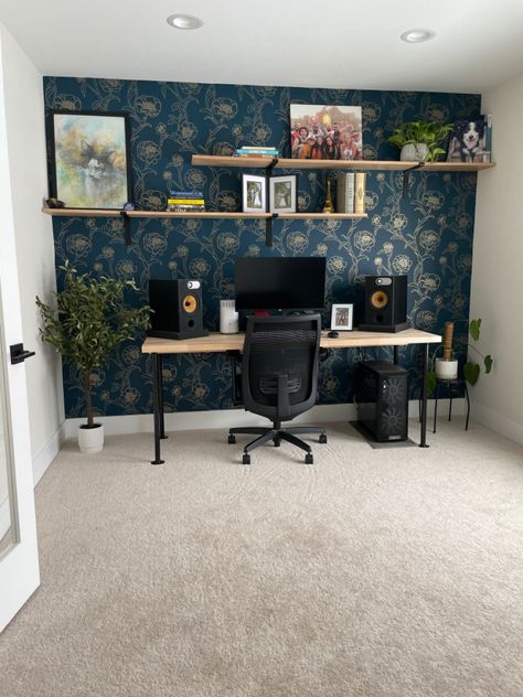 We decided to add an accent wall using bold patterned wallpaper and custom oak shelves for the office. Pattern Wallpaper Accent Wall, Apartment Wallpaper Accent Wall, Wallpapered Office Wall, Wall Shelves In Office, One Wall Wallpaper Office, Office With Accent Wallpaper, Statement Wall In Office, Accent Wall Wallpaper Office, Wallpaper Desk Area