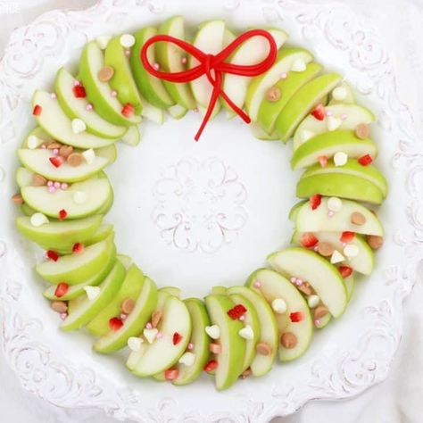 Apple Nachos or Caramel Apple Slices in the shape of a wreath are a great treat for Christmas parties! Quick and easy to arrange, too! #wreath #christmaswreath #christmaswreathtreats #christmastreats #christmastreatideas #easyrecipe #apples #applenachos #caramelapples #caramelappletoppings #holidaytreats #christmas #holidays #partyfood #partyideas Christmas Fruit Ideas, Natal, Christmas Fruit Tray, Christmas Treat Ideas, Christmas Apples, Caramel Apple Slices, Apple Nachos, Apple Christmas, Apple Wreath